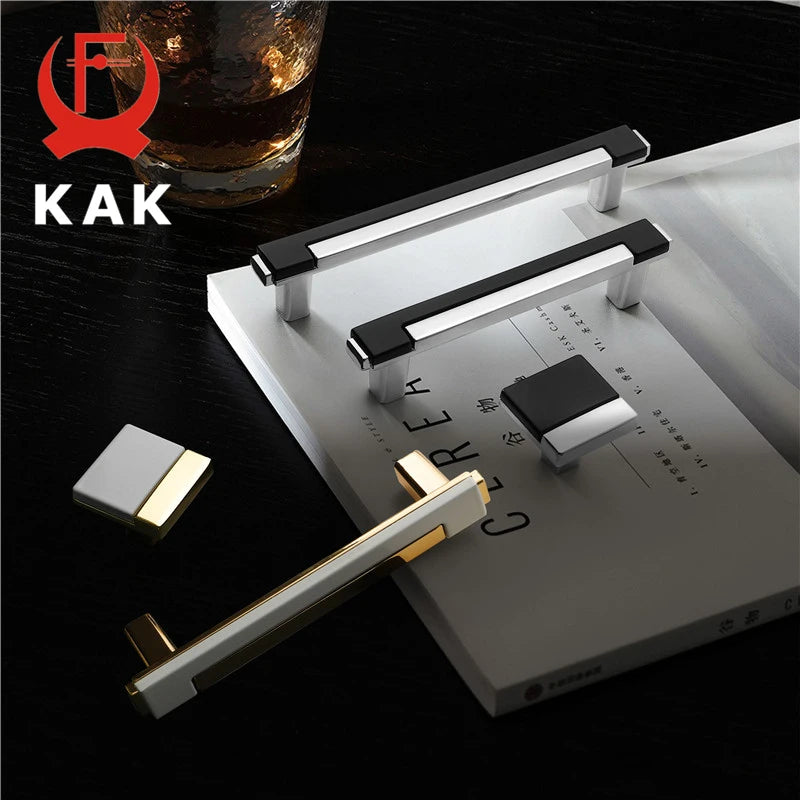 Metallic handles on a surface with a glass of whiskey and 'KAK' branding.