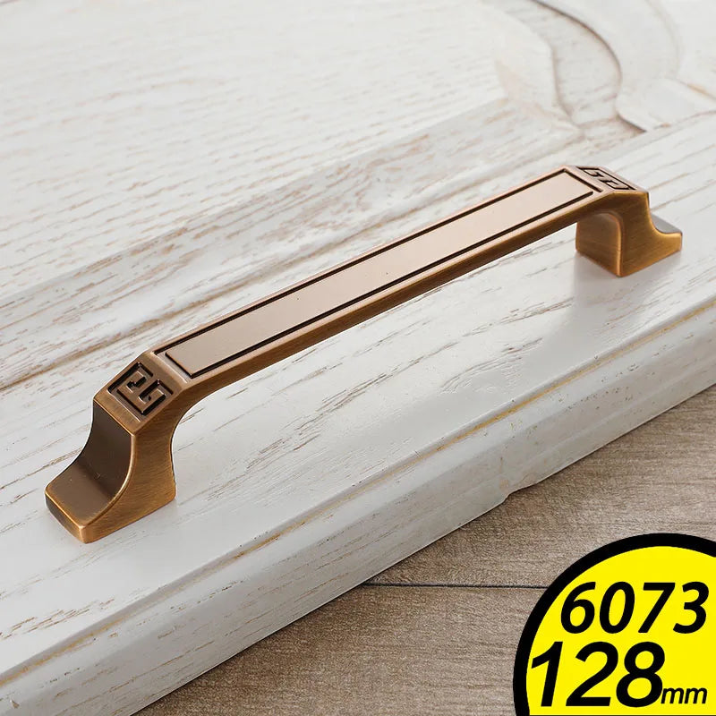 Antique brass vintage cabinet handles mounted on white wooden drawer with decorative edges