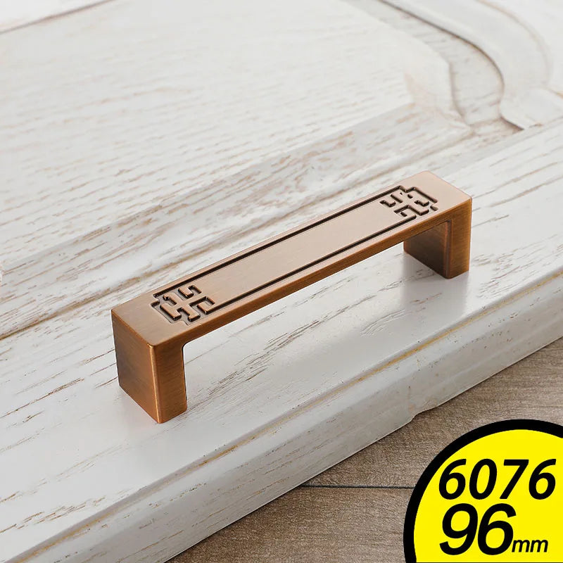 Bronze Vintage Cabinet Handles with decorative square patterns on white wooden cabinet door