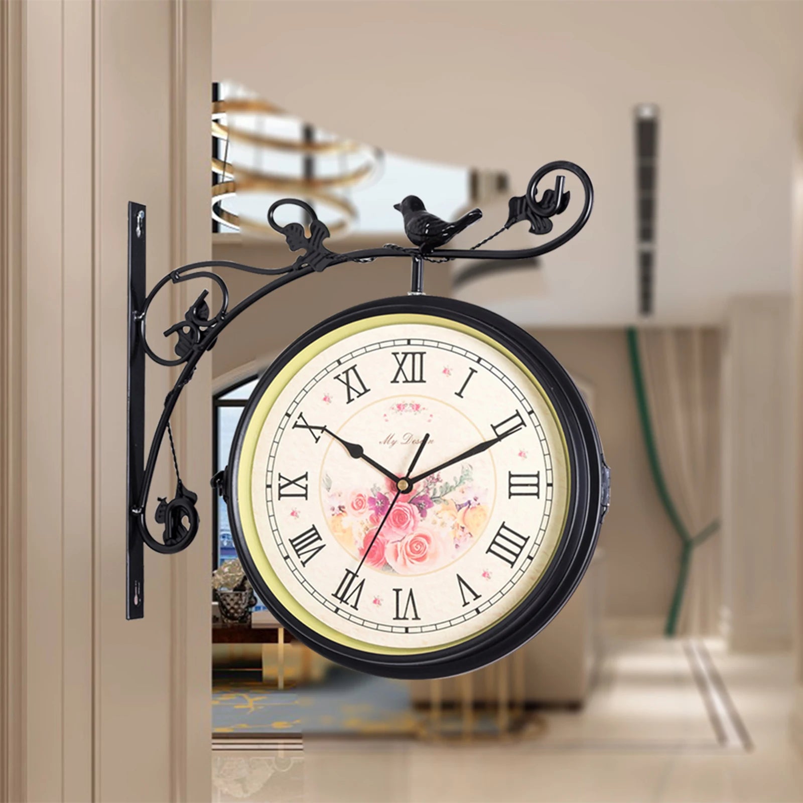 Double sided 25cm silent wall mounted clock with Roman numerals and floral design, mounted on decorative metal bracket with bird motif, suitable for indoor and outdoor use.