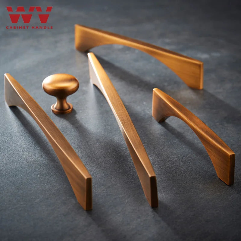 Antique brass cabinet handles and knob set on a dark surface, featuring sleek and modern design for furniture and kitchen cabinets.