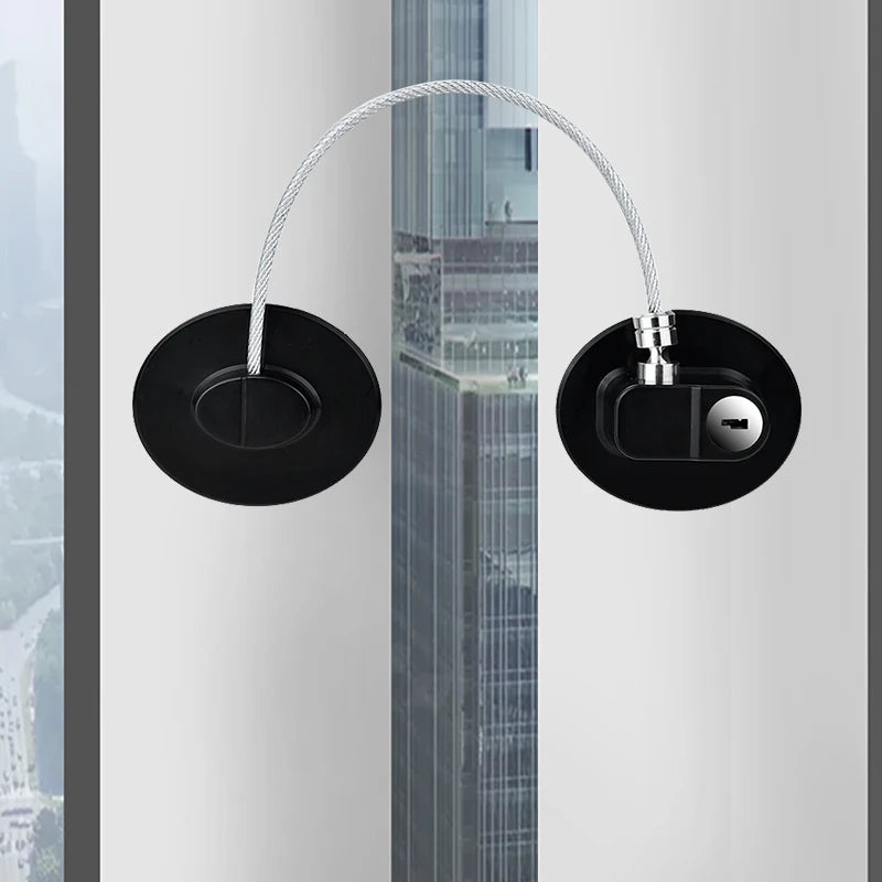 Password baby safety door and window lock with key for child protection, featuring black circular design and steel cable on a window.