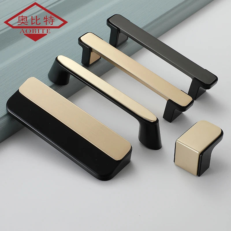 Set of black and gold luxury kitchen cabinet handles and knobs on a blue wooden surface.