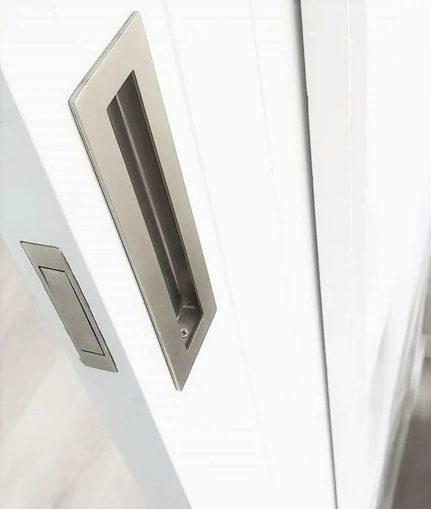 Stainless steel concealed handle on white sliding door, featuring a sleek and modern rectangular design.