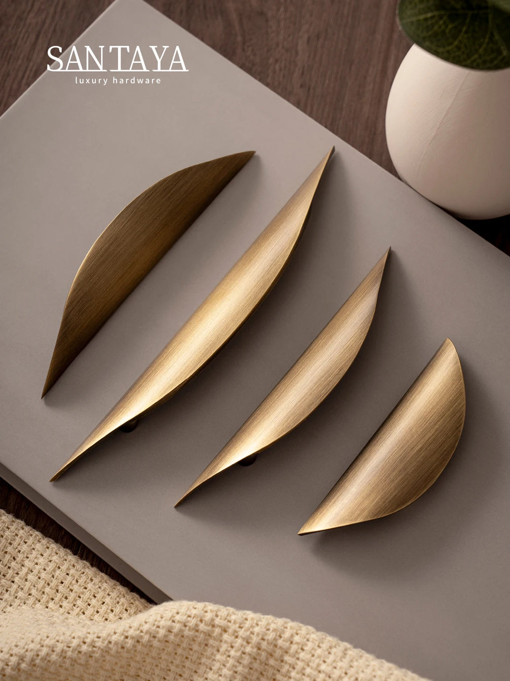 Antique brass pulls with sleek design on neutral surface, featuring golden-brass finish.