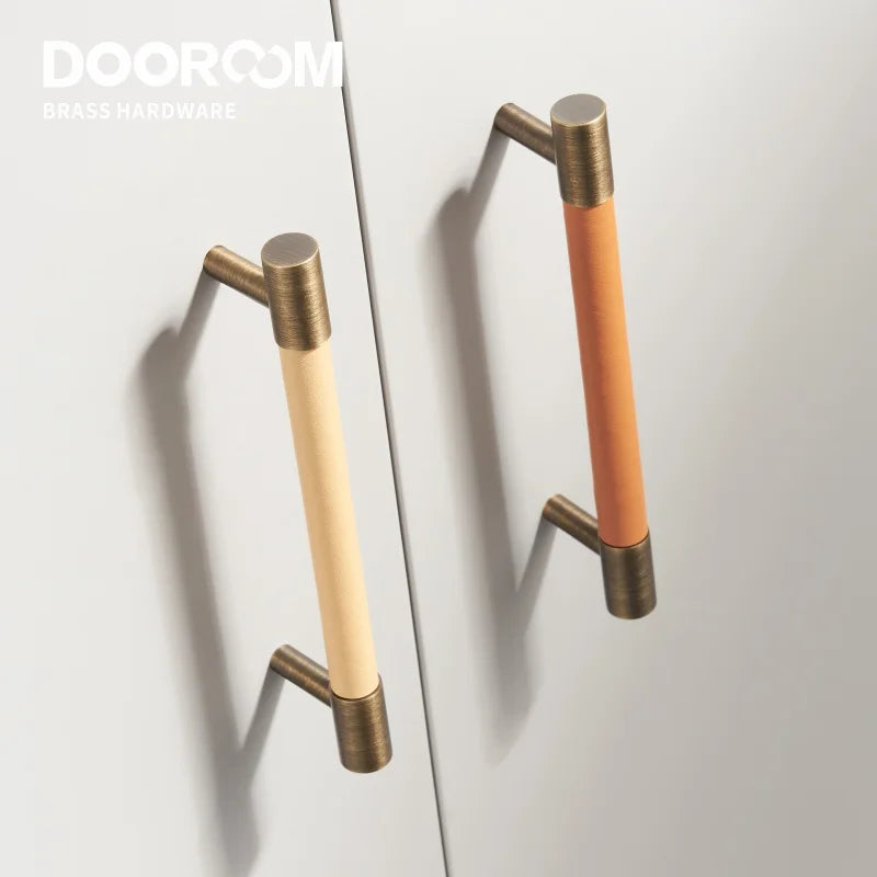 Dooroom brass furniture handles with real leather in Nordic design on a light cabinet.