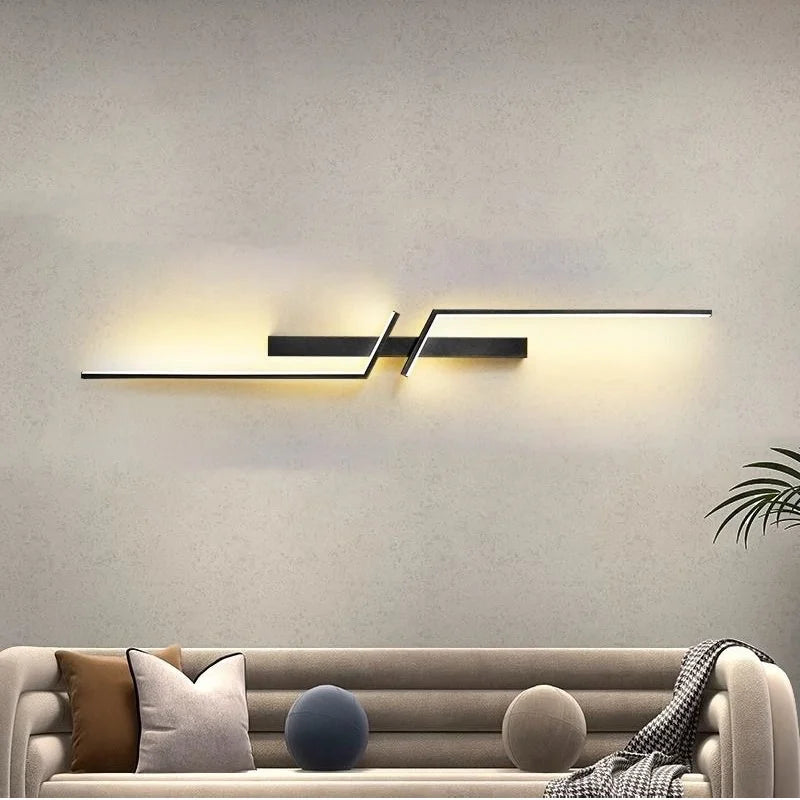 Modern LED wall lamp with minimalist design in a living room setting, featuring a black finish and warm lighting.