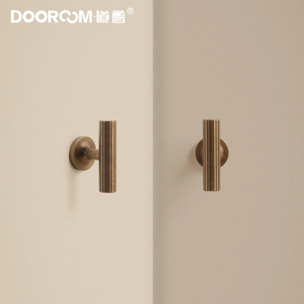 Dooroom vintage style brass furniture handles with vertical stripe design mounted on a light surface.