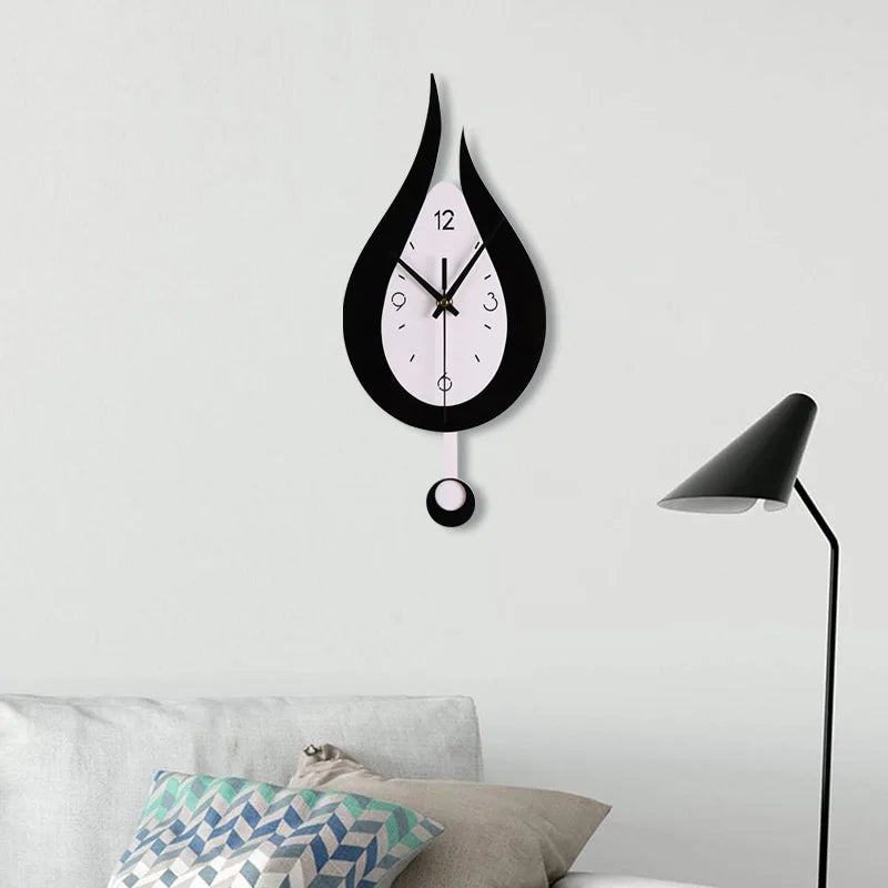 Waterdrop shaped black and white swinging wall clock in a modern living room setting.