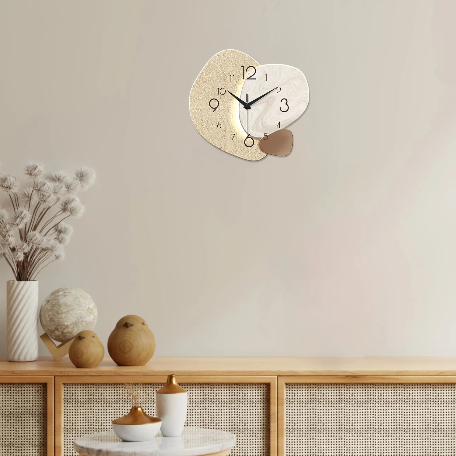 Modern simple wall clock with silent quartz movement and abstract design on a beige wall above a decorative console table.