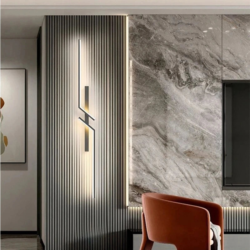 Modern minimalist strip LED wall light on grooved panel with warm white glow in a contemporary living room setting.