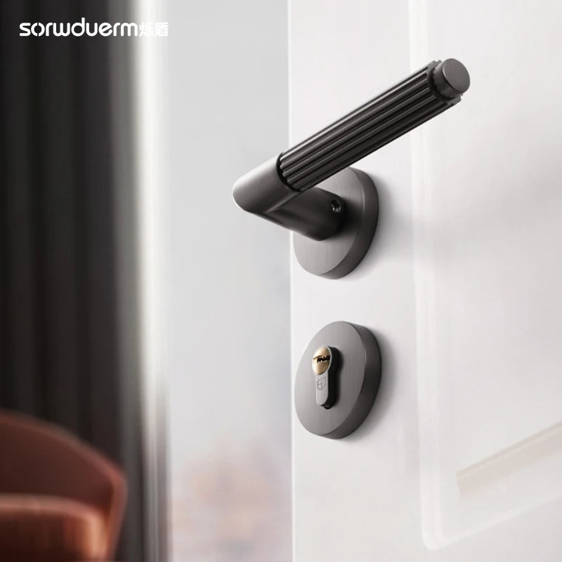 Black gray brushed wire bedroom door lock with a modern ergonomic handle on a white wooden door.