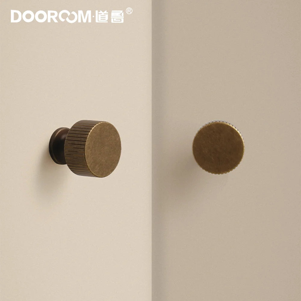 Dooroom vintage style brass furniture handles with round knob design mounted on a neutral cabinet surface.