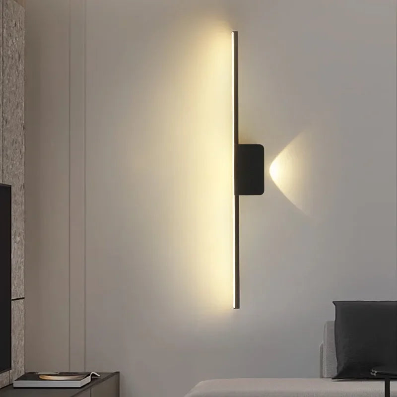 Modern minimalist LED wall lamp with warm ambient lighting in a bedroom setting.