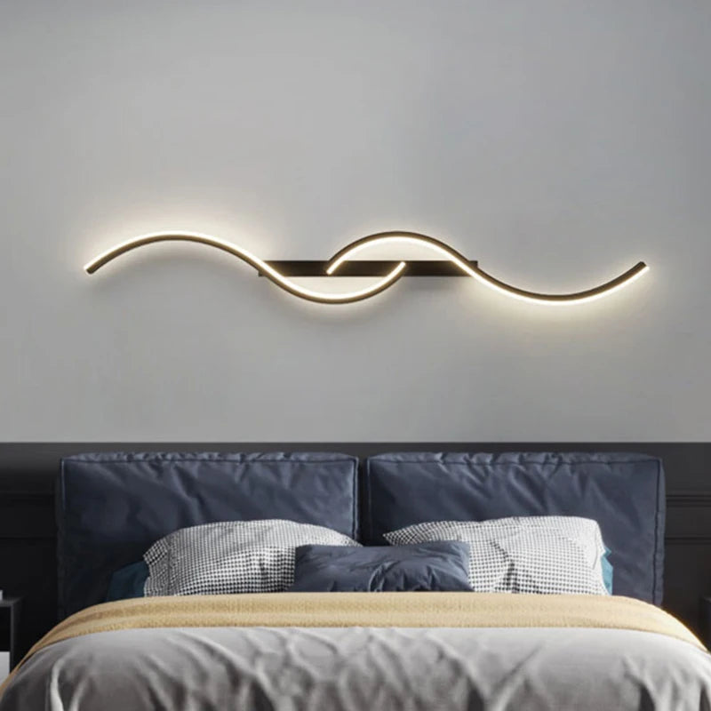 Modern minimalist LED wall lamp with warm white light above a bed in a stylish bedroom setting.