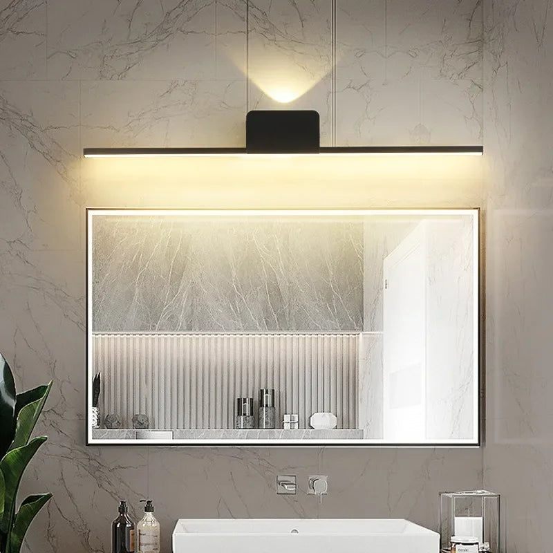 Modern minimalist LED wall lamp above a mirror in a marble bathroom setting, providing warm ambient lighting.