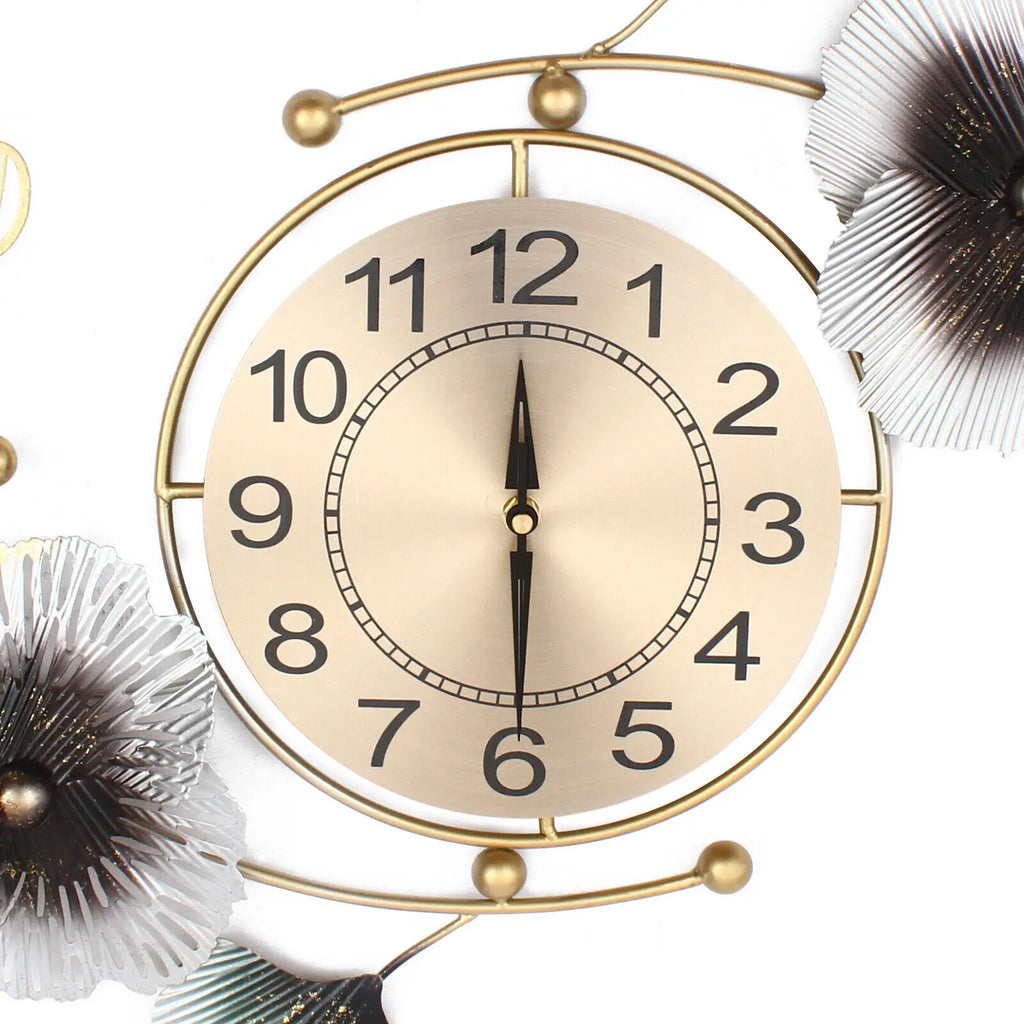 Large wall clock with gold metal frame and ginkgo leaf design, featuring black numerals and hands.