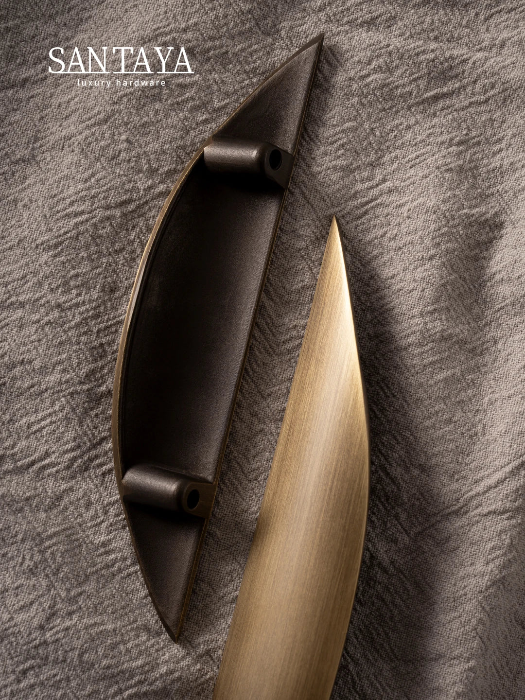 Antique brass pulls with a sleek design showcased on a textured fabric background, highlighting their elegant finish.
