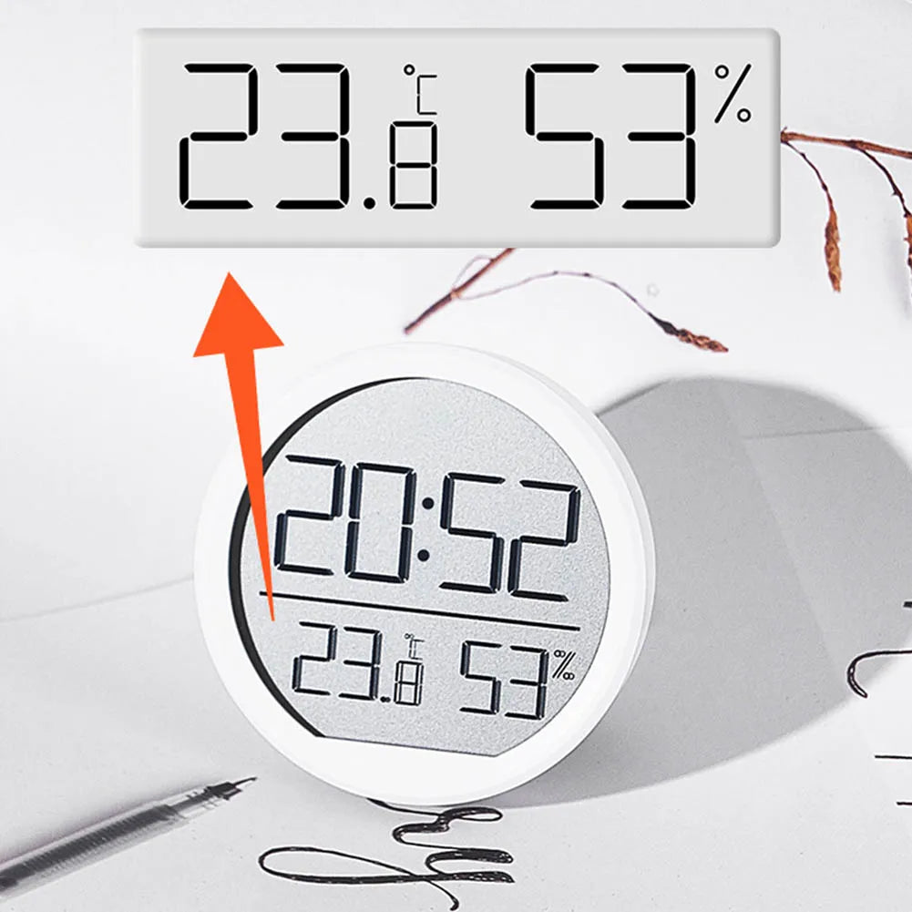 Multi-function electronic clock displaying time, temperature, and humidity with a modern circular design, ideal for home use.