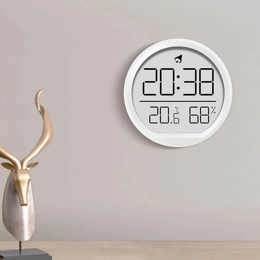 Modern multi-function wall-mounted clock displaying time, temperature, and humidity in a minimalist home setting.