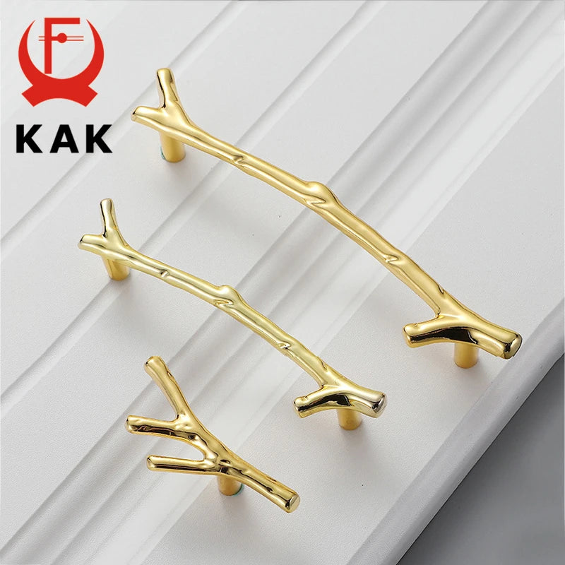KAK tree branch furniture handles in gold on a white surface, showcasing elegant design and glossy finish.