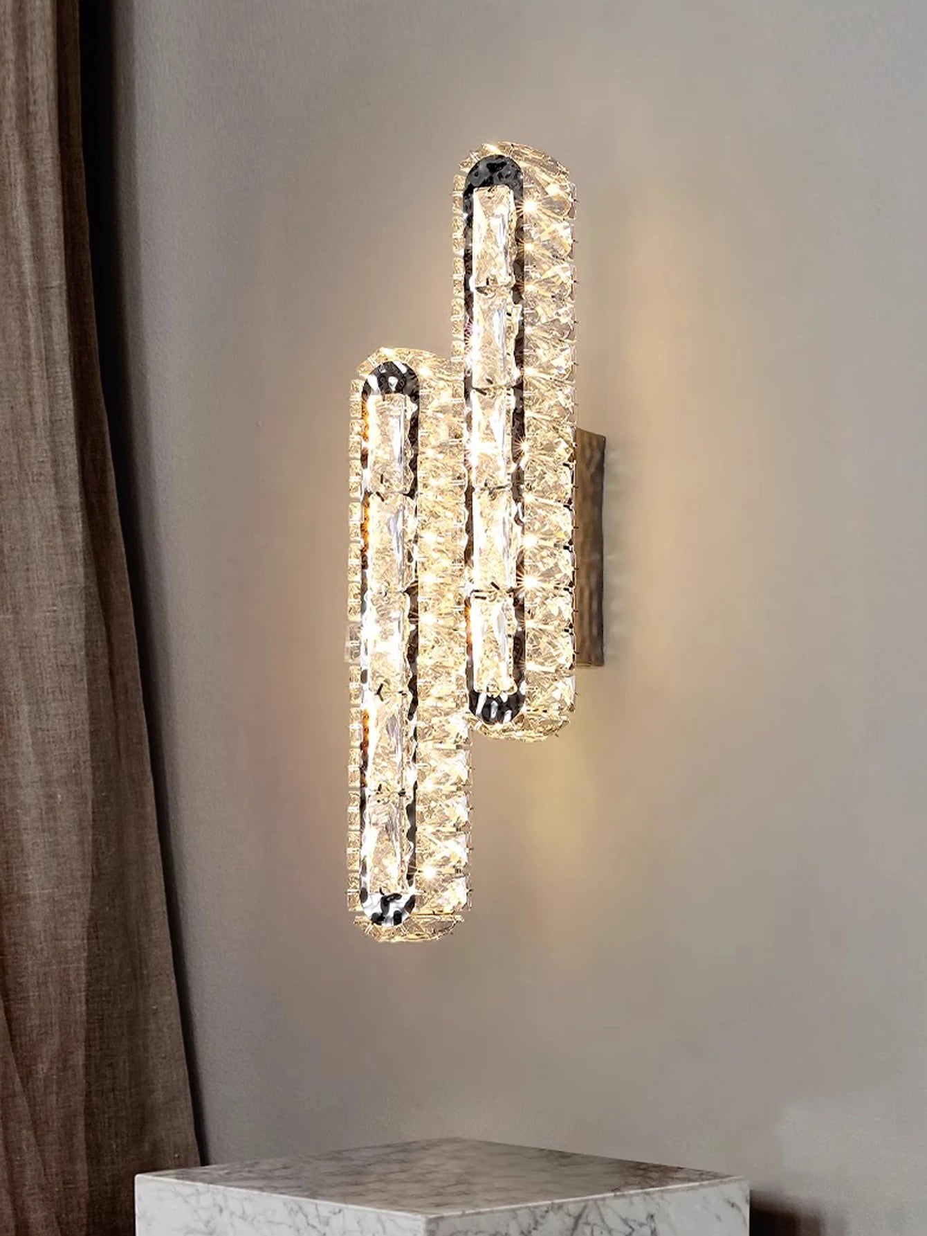 Gold and silver wall lamp with crystal strips mounted on a wall, ideal for living room or corridor decoration.