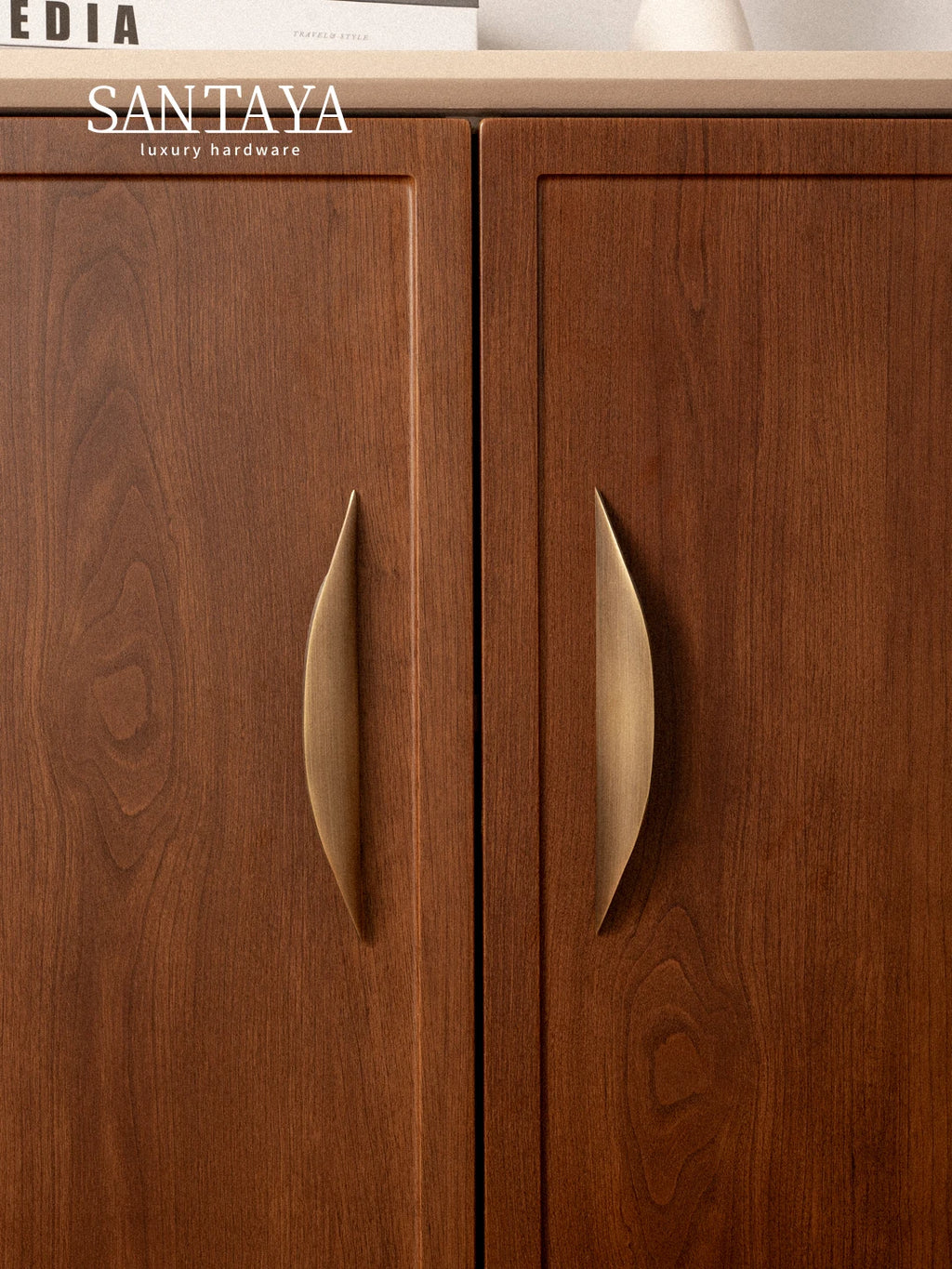 Antique brass pulls on wooden cabinet doors, showcasing an elegant and classic design.