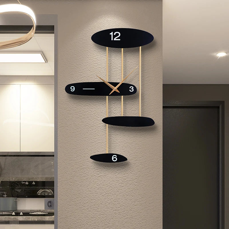 Modern light luxury wall-mounted clock with black ovals and gold accents on a beige wall, featuring numbers 12, 3, 6, 9.