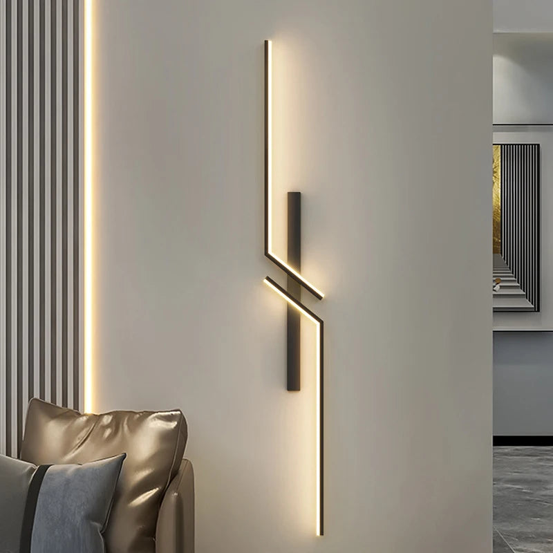 Modern creative strip LED wall light in a minimalist bedroom setting, mounted beside a sofa with warm white illumination.