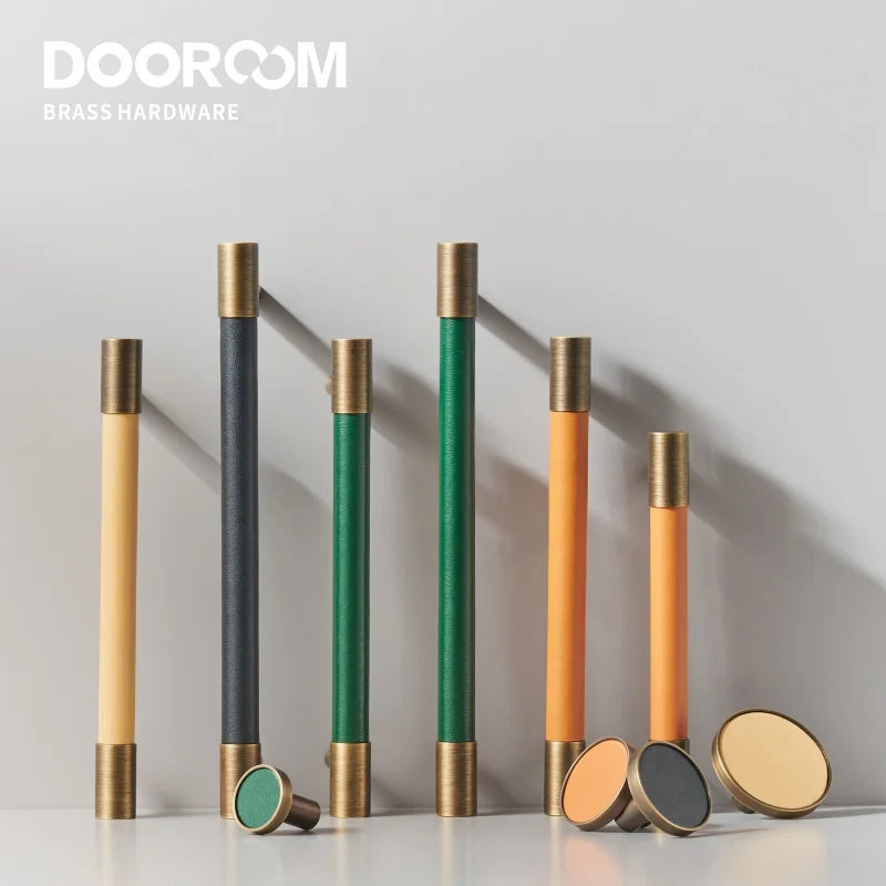 Dooroom brass furniture handles and knobs wrapped in real leather, featuring a Nordic design in beige, black, green, and orange colors.