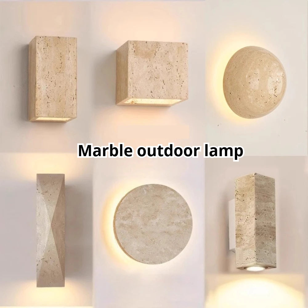 Travertine wall lamps in geometric shapes providing warm ambient lighting, suitable for outdoor spaces.