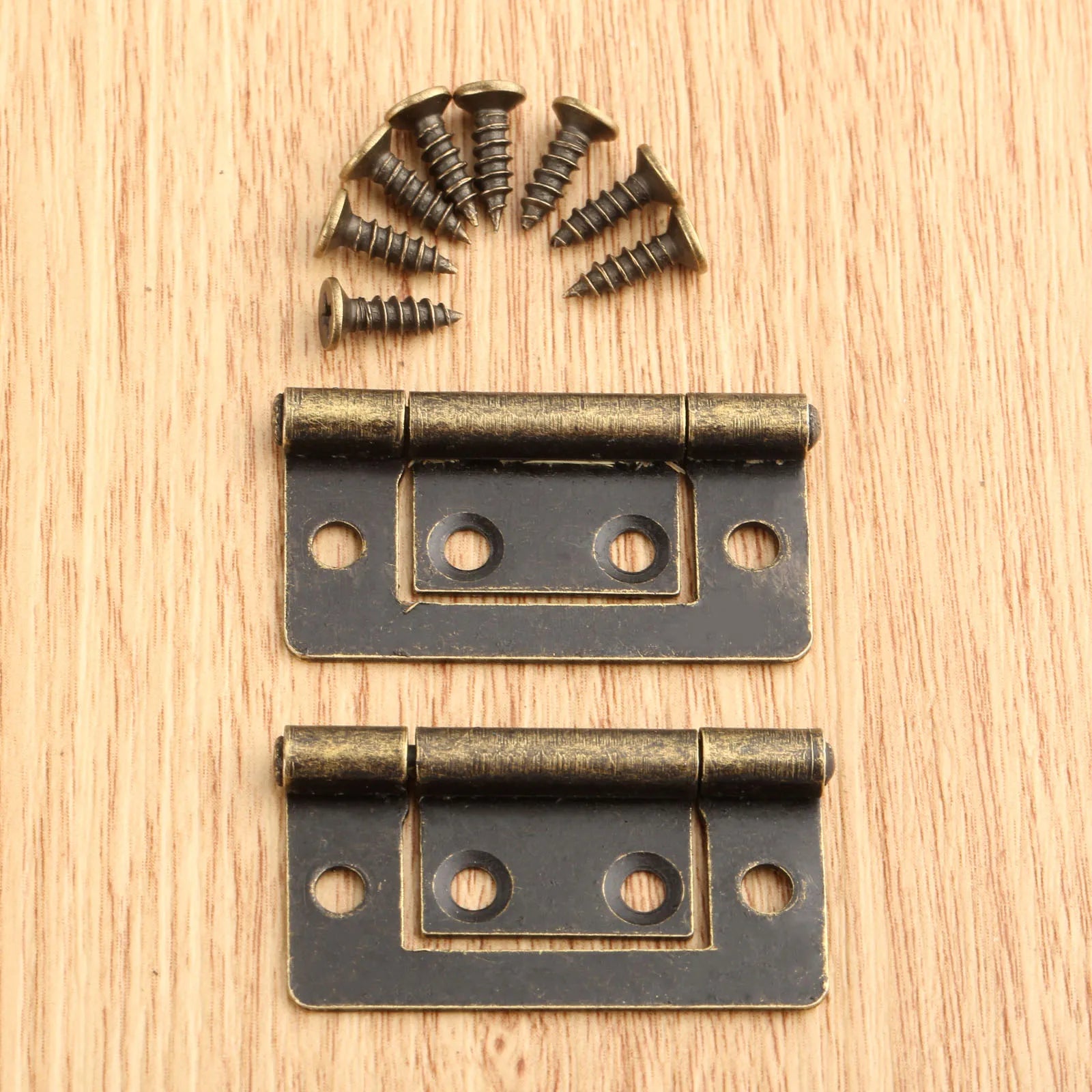 2pcs Vintage Jewelry Wooden Box Decorative Hinges 38x20mm with screws, antique bronze finish, on a wooden surface.