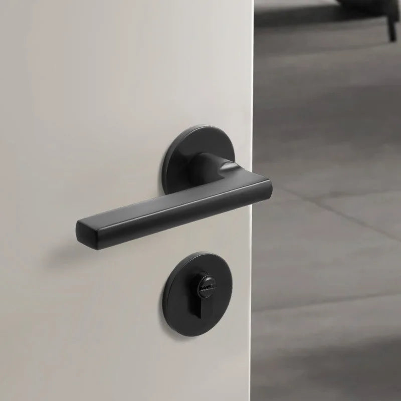 Black American style indoor door lock with integrated magnetic silent wooden handle on a white door.