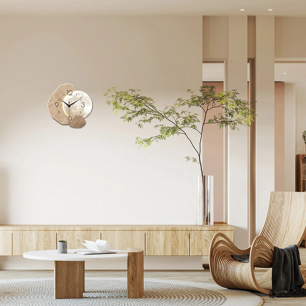 Modern simple silent wall clock with moon design in a stylish living room featuring wooden furniture and greenery.