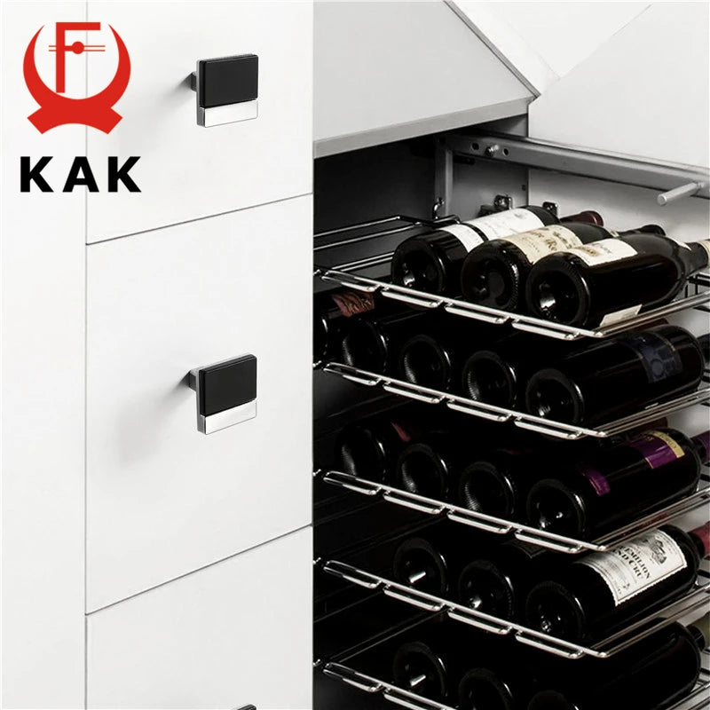 Modern black and chrome cabinet handles on white cabinets next to a wine rack filled with bottles.